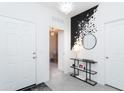 Bright foyer featuring a modern chandelier, decorative wall art and access to a room with natural light at 36076 W Santa Barbara Ave, Maricopa, AZ 85138