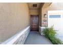 Inviting front porch with a cozy mat and patriotic decor, adjacent to a well-maintained two-car garage at 36076 W Santa Barbara Ave, Maricopa, AZ 85138