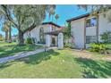 Inviting townhome with a lush green lawn, mature trees, and a charming pergola-covered entrance at 3637 E Monterosa St # 8, Phoenix, AZ 85018