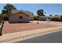 Exterior view of brick home with manicured desert landscape, a paved driveway, and mature trees at 4112 S Grandview Ave, Tempe, AZ 85282