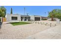 Charming home featuring desert landscaping, decorative stone walkway, and a two-car garage at 4842 E Surrey Ave, Scottsdale, AZ 85254