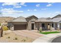Charming single-story stone home boasts a covered porch with seating and desert landscape at 520 E Ashurst Dr, Phoenix, AZ 85048