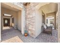 Inviting front porch with stone accents, tiled flooring, and cozy seating area for relaxing at 520 E Ashurst Dr, Phoenix, AZ 85048