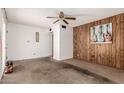 Living room with wood accent wall, carpet flooring, ceiling fan and an entry door on the left at 539 E Pebble Beach Dr, Tempe, AZ 85282