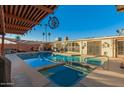 Backyard featuring a sparkling pool, covered patio, outdoor kitchen, and well-maintained landscaping at 6217 W Orange Dr, Glendale, AZ 85301