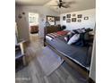 Primary bedroom with wood-look laminate floors, ceiling fan, and multiple decorations at 625 W Mckellips Rd # 358, Mesa, AZ 85201