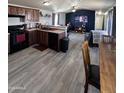 Open kitchen with dark wood cabinets, black appliances and laminate floors at 625 W Mckellips Rd # 358, Mesa, AZ 85201