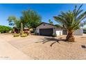 Exterior view of home with two-car garage and desert landscaping at 7731 E Rose Ln, Scottsdale, AZ 85250