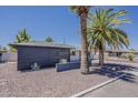 Attractive single-story home showcasing a modern exterior and a landscaped gravel yard with mature trees at 8137 E Indian School Rd, Scottsdale, AZ 85251