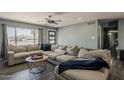 Comfortable living room with a large sectional sofa, modern ceiling fan, and a view to the front yard at 8137 E Indian School Rd, Scottsdale, AZ 85251