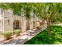 Charming home exterior showcasing a landscaped yard, covered patios, and neutral-toned walls with arched entries at 905 S Osborn Ln, Gilbert, AZ 85296
