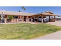 Charming single-story residence featuring covered parking, a neat front lawn, and an inviting, decorated entrance at 10439 W Kingswood Cir, Sun City, AZ 85351