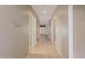 Inviting hallway featuring neutral paint, tile flooring, and doorways to living spaces at 13657 W Holly St, Goodyear, AZ 85395