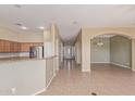 Spacious open floorplan with tile flooring, connecting the kitchen, dining, and living areas at 13657 W Holly St, Goodyear, AZ 85395