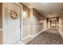 Hallway with carpeting, neutral walls, and a decorative wreath on the apartment door at 14575 W Mountain View Blvd # 12309, Surprise, AZ 85374