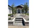 Inviting home entrance with well-maintained landscaping, stone pathway, and modern architectural details at 1650 W Lucky Ln, Queen Creek, AZ 85144