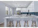 Bright kitchen features white cabinetry, stainless steel appliances, quartz countertops, and a blue tiled backsplash at 1694 E Dogwood Ln, Gilbert, AZ 85295