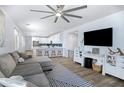 Open-concept living area flowing into a modern kitchen with white cabinetry and a large TV at 1694 E Dogwood Ln, Gilbert, AZ 85295