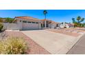 A lovely home featuring a spacious driveway, desert landscaping, and a charming tile roof at 17025 E De Anza Dr, Fountain Hills, AZ 85268