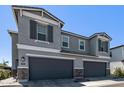 Close-up showcasing a charming two-story home with gray facade and dark garage doors at 17118 N 50Th Way, Scottsdale, AZ 85254