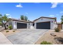 Spacious driveway leading to a three-car garage, complemented by desert landscaping and a well-maintained facade at 1720 W Aloe Vera Dr, Phoenix, AZ 85085