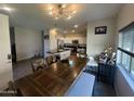 Open-concept kitchen and dining area with pendant lighting, white cabinets, and a wooden dining table set at 1814 W Minton St, Phoenix, AZ 85041
