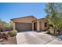 Inviting single-story home with a two-car garage and desert landscaping, offering curb appeal at 1965 N 213Th Dr, Buckeye, AZ 85396