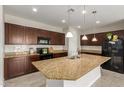 Spacious kitchen featuring a large island, dark wood cabinets, and modern stainless steel appliances at 19889 W Sherman St, Buckeye, AZ 85326