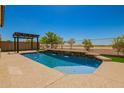 Backyard pool with water feature, pergola, and desert landscaping offering a private oasis at 19889 W Sherman St, Buckeye, AZ 85326