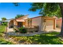 Charming single-story home featuring an attached garage, inviting entrance, and mature landscaping at 212 Leisure World --, Mesa, AZ 85206