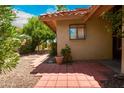 Side view of home with brick paved patio, desert landscaping and beige stucco exterior with a window reflection at 4225 E Sandia St, Phoenix, AZ 85044