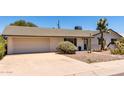 Welcoming home featuring desert landscaping, a two-car garage, and a well-manicured yard at 6820 E Pinchot Ave, Scottsdale, AZ 85251