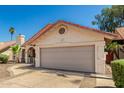 Single-story home featuring a neutral color scheme, a two car garage, desert landscaping, and a red tile roof at 7139 W Mcrae Way, Glendale, AZ 85308