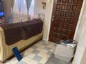View of a room with a couch and a brown front door with gray tiled flooring at 774 E Morningside Dr, Phoenix, AZ 85022