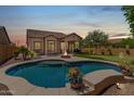 Inviting backyard oasis with a sparkling pool, fire pit, putting green and outdoor seating area for relaxing evenings at 8304 E Inca St, Mesa, AZ 85207