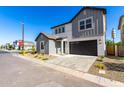 Charming two-story home featuring gray tones, a two-car garage and a welcoming front yard at 9249 E Sector Dr, Mesa, AZ 85212