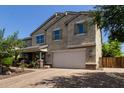 Charming two-story home with stucco exterior, a paver driveway, a two-car garage and manicured lawn at 9372 W Louise Dr, Peoria, AZ 85383