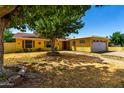 A charming yellow home with an established lawn and mature trees in a quiet neighborhood at 9714 N 55Th Dr, Glendale, AZ 85302