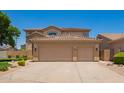 Spacious three-car garage and large driveway on tan two story home at 986 W Citrus Way, Chandler, AZ 85248