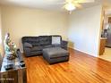 Inviting living room featuring laminate floors, a ceiling fan, and comfortable gray sofa at 10726 W Kelso Dr, Sun City, AZ 85351