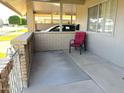 Comfortable patio space featuring brick pillars, iron railing, and a red chair at 10726 W Kelso Dr, Sun City, AZ 85351