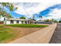 Lovely single story home featuring a carport and a vibrant green front lawn at 1228 E Fremont Dr, Tempe, AZ 85282