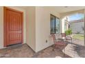 Inviting front porch with a red door, brick pavers, and comfortable seating under a covered entry at 14200 W Village Pkwy # 2128, Litchfield Park, AZ 85340
