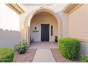 Welcoming arched entry with an iron security door, desert landscaping, and a cozy bench seating area at 19403 E Apricot Ln, Queen Creek, AZ 85142