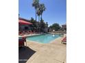 Community swimming pool with lounge chairs, umbrellas, and well-kept patio area at 1941 S Pierpont Dr # 2062, Mesa, AZ 85206