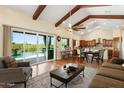 Spacious living room with patio access, beamed ceilings, and open layout to the dining area at 1943 E Paso Nuevo Dr, Phoenix, AZ 85086