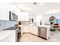 Modern kitchen with stainless steel appliances, quartz countertops and a view of the open-concept living space at 2511 W Queen Creek Rd # 325, Chandler, AZ 85248