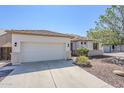 Charming home exterior featuring a well-maintained lawn, desert landscaping, and two-car garage at 2755 N 103Rd Ave, Avondale, AZ 85392