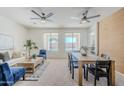 Open-concept living and dining area with large windows, modern ceiling fans, and stylish furniture at 2755 N 103Rd Ave, Avondale, AZ 85392