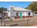 Charming white home with red brick accents and a bright turquoise front door at 2802 E Virginia Ave, Phoenix, AZ 85008